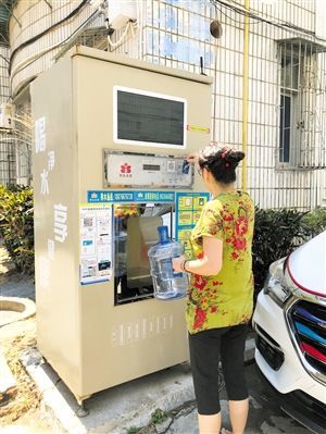 5月24日，瓊山區(qū)上丹花苑小區(qū)居民陳女士在使用共享凈水機(jī)取水。 本報(bào)記者 陳歆卓 攝